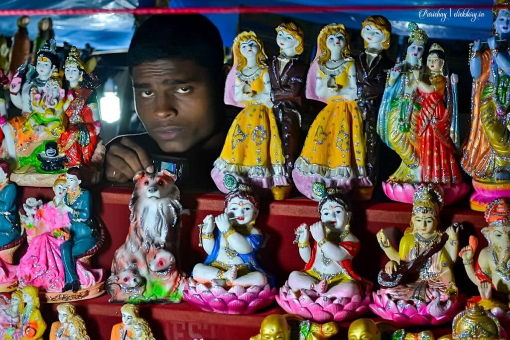 shopkeeper with idols street photography